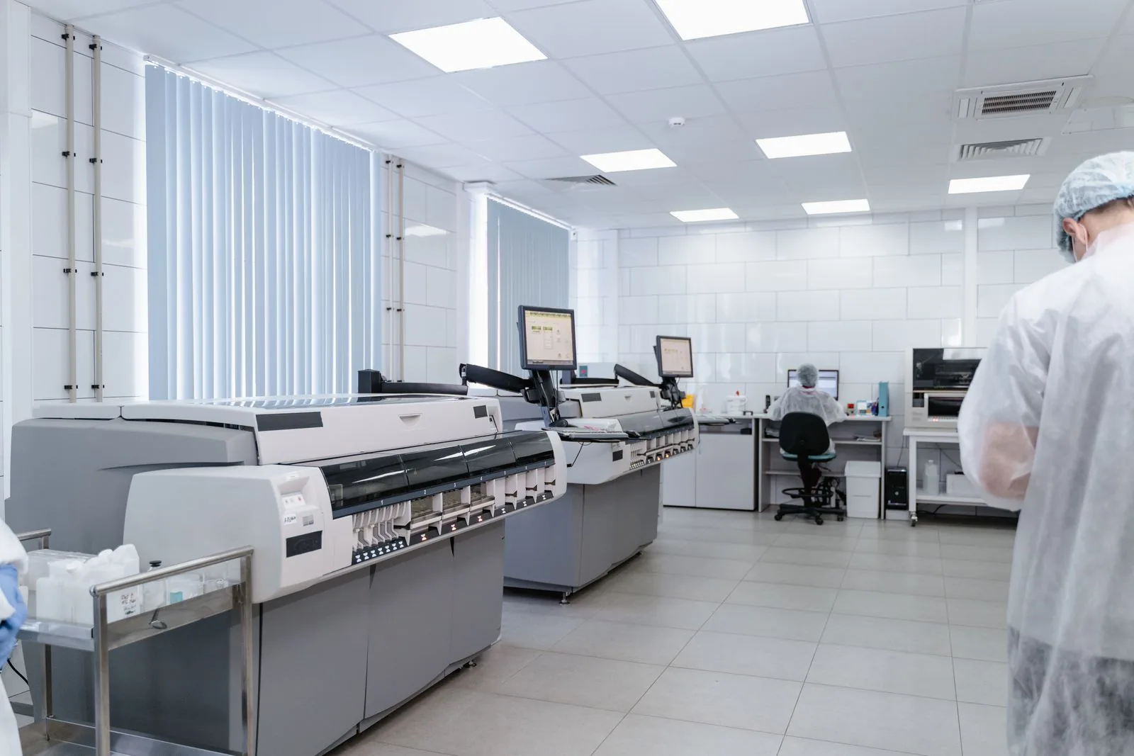 Laboratorio luminoso e sterile con attrezzature di ricerca all'avanguardia e professionisti al lavoro.